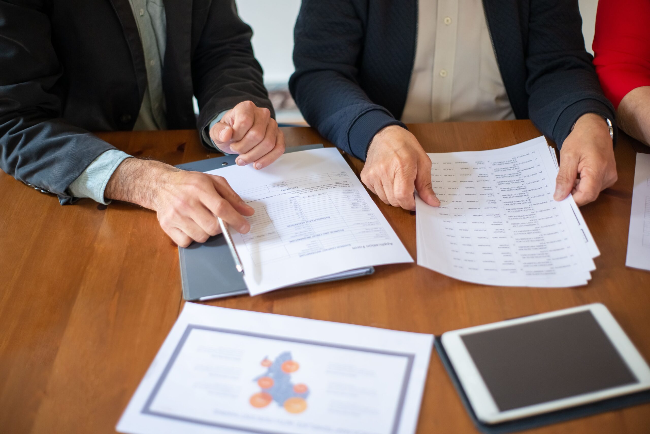 Two business professionals discussing and reviewing documents during a meeting.